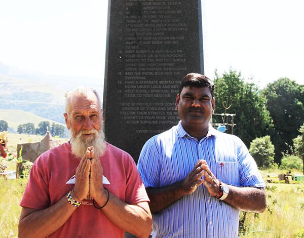 CJ and Ishwar Ramlutchman standing in prayer at the Sivananda Peace Pillar